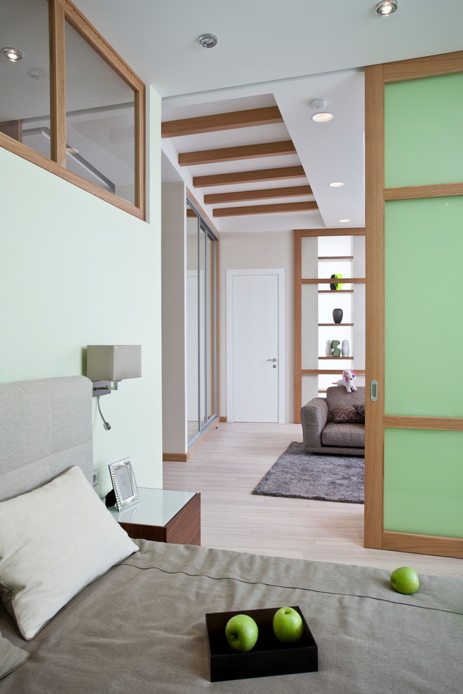 Пример оригинального дизайна: хозяйская спальня среднего размера в современном стиле с паркетным полом среднего тона, бежевым полом и зелеными стенами
