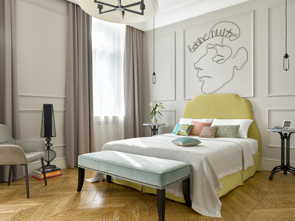 Modelo de dormitorio principal clásico renovado con paredes grises, suelo de madera en tonos medios y suelo marrón