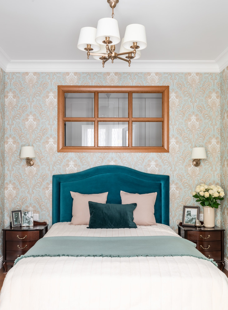 Modelo de dormitorio principal tradicional pequeño con paredes azules, suelo de madera en tonos medios y suelo marrón