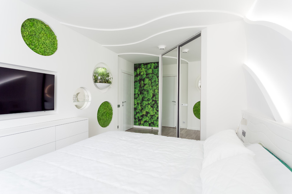 Ejemplo de dormitorio principal actual de tamaño medio sin chimenea con paredes blancas, suelo de bambú y suelo gris