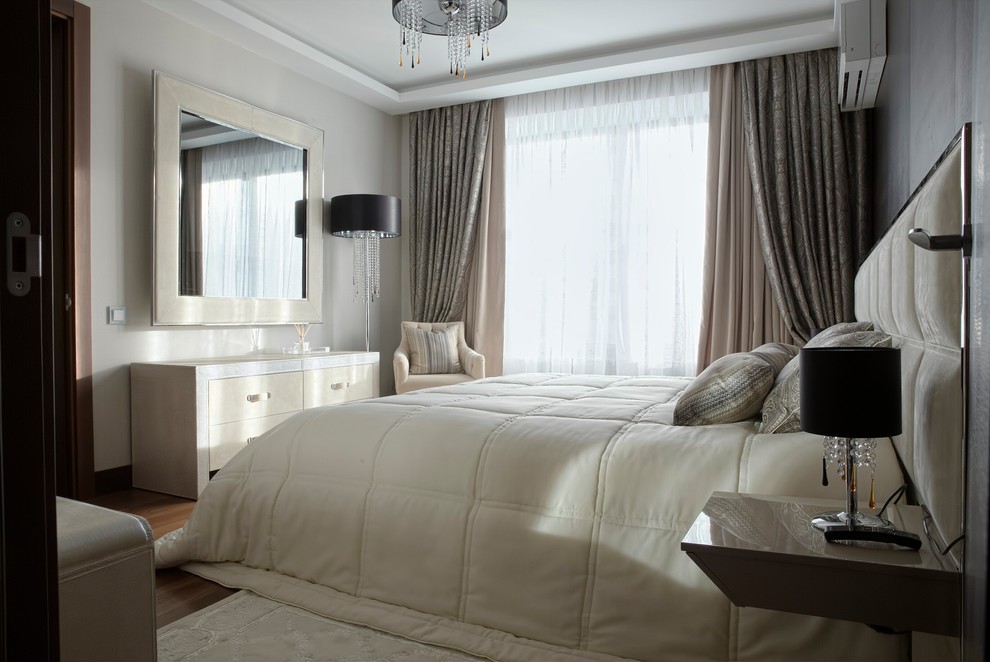Example of a mid-sized trendy master medium tone wood floor bedroom design in Moscow with pink walls