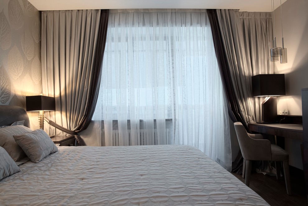 Ejemplo de dormitorio principal contemporáneo de tamaño medio con paredes grises y suelo de madera en tonos medios