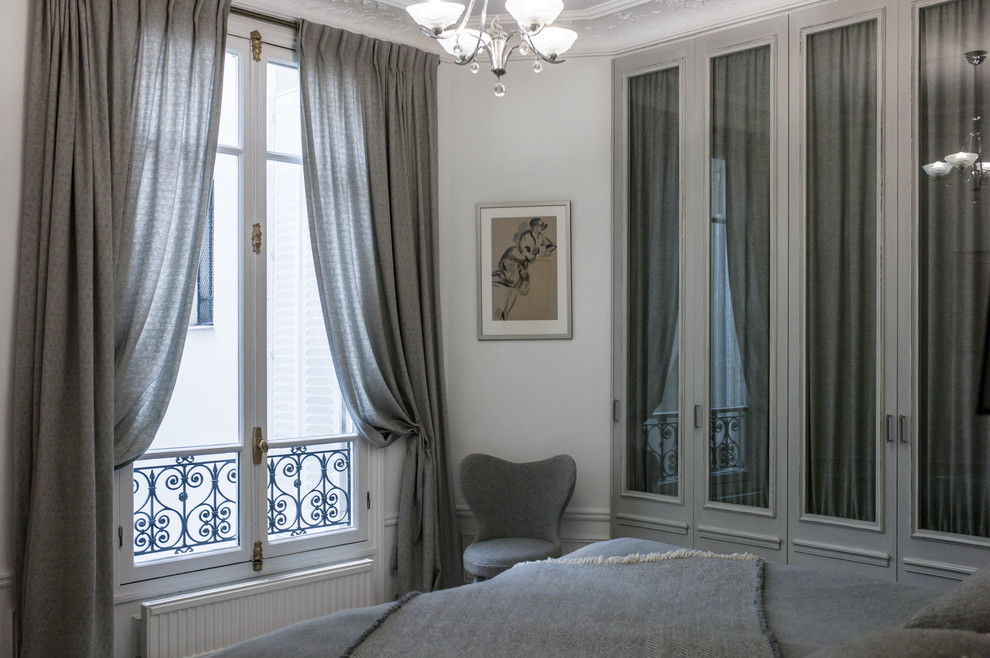 Klassisches Hauptschlafzimmer mit weißer Wandfarbe und braunem Holzboden in Paris