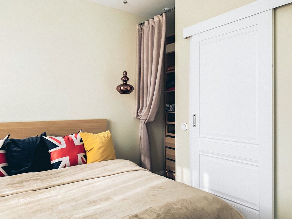 Imagen de dormitorio principal escandinavo de tamaño medio con paredes beige, suelo laminado y suelo marrón
