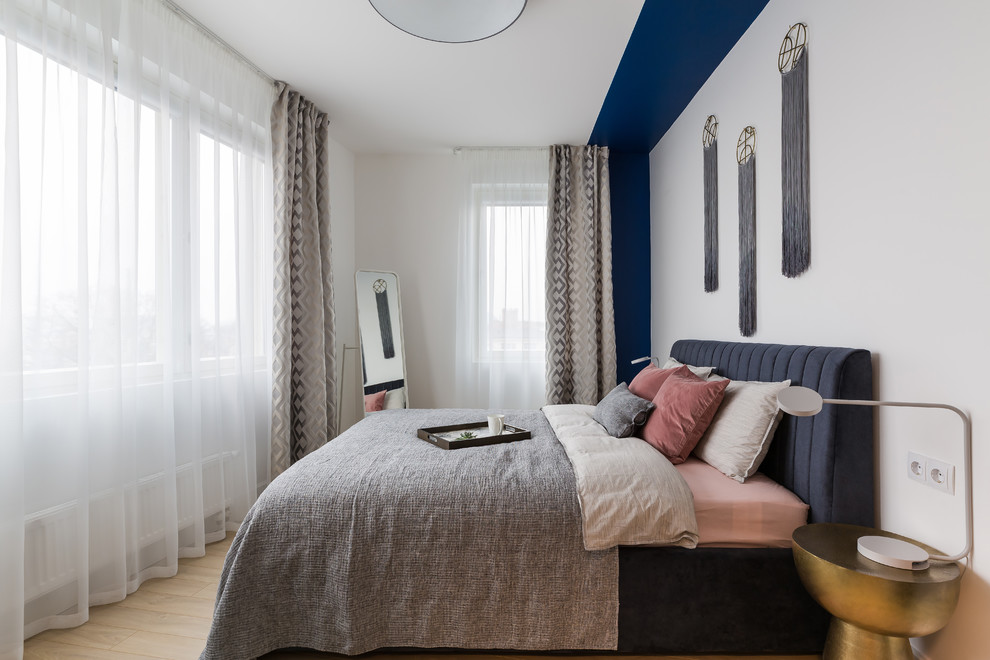 Idee per una camera matrimoniale minimal con pareti bianche, parquet chiaro e pavimento beige