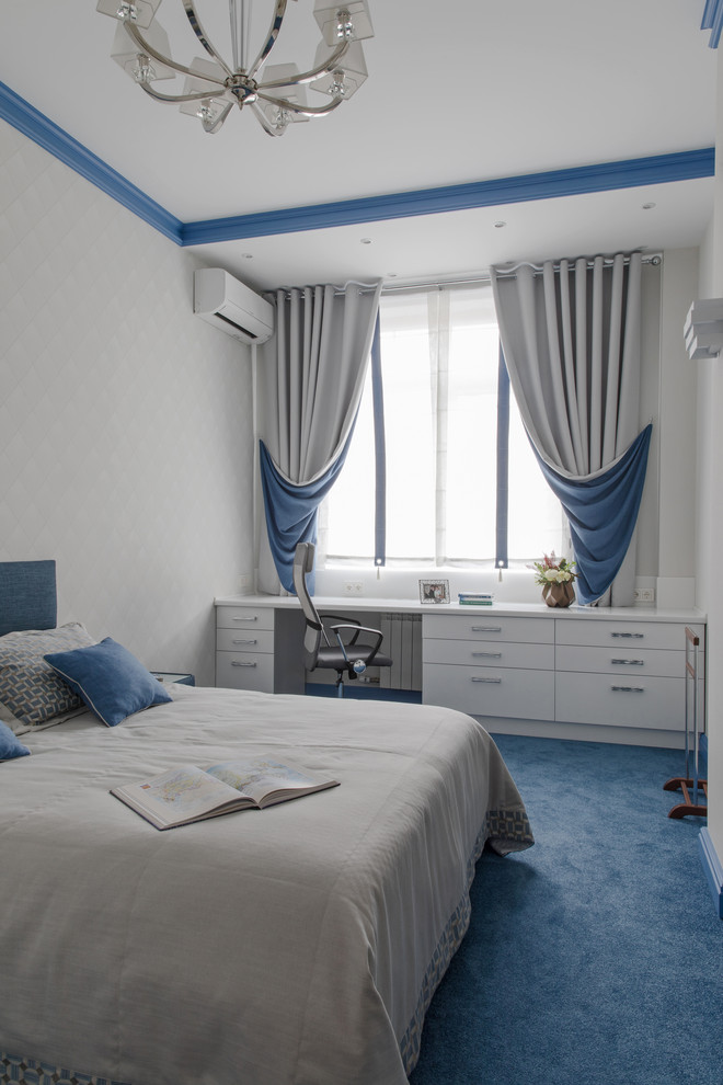 Inredning av ett modernt sovrum, med vita väggar, heltäckningsmatta och blått golv