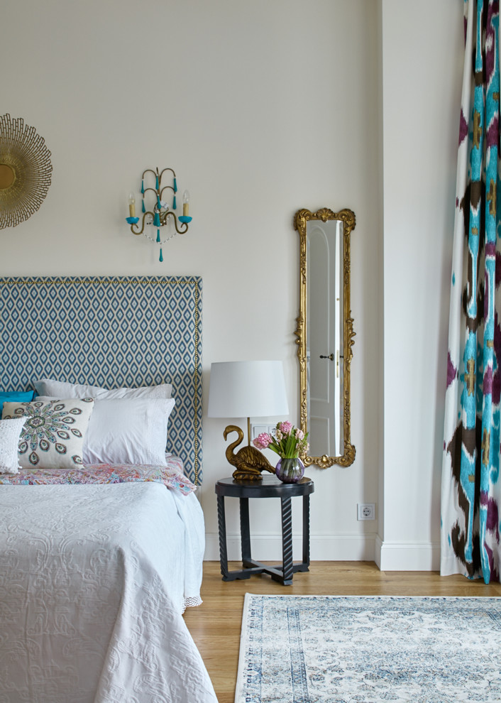 Example of a transitional master medium tone wood floor bedroom design in Moscow with white walls and no fireplace