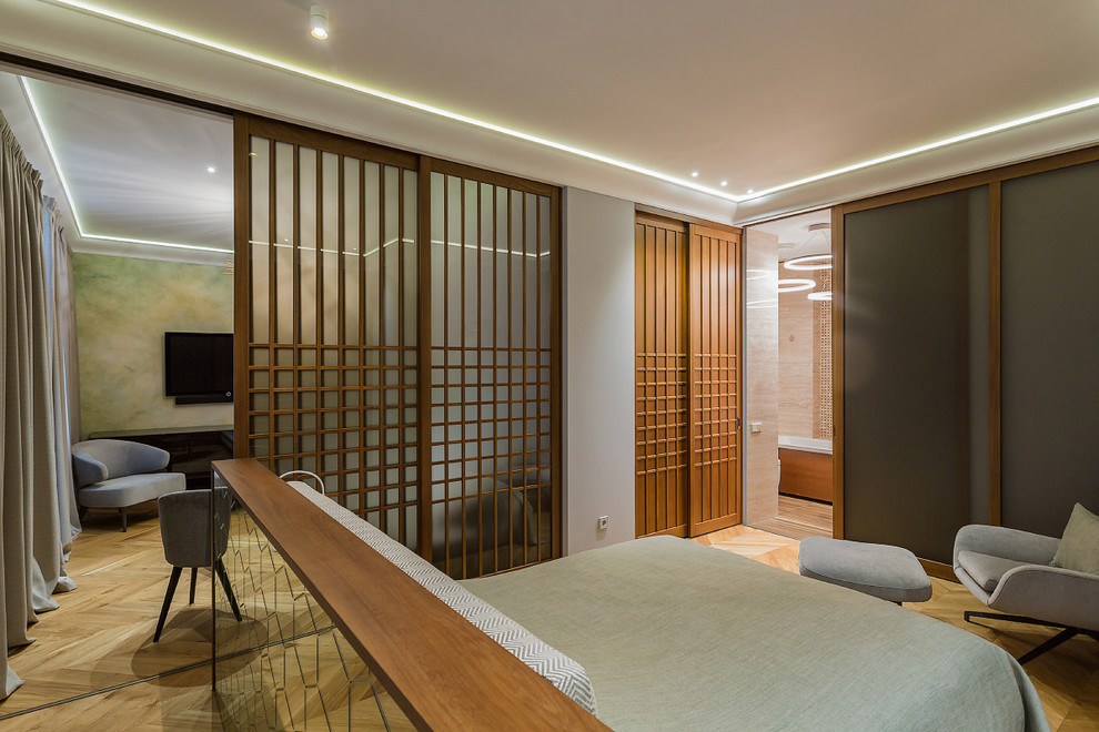 Foto de dormitorio principal contemporáneo con paredes blancas, suelo de madera en tonos medios y suelo marrón