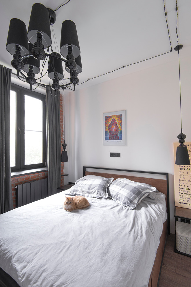 На фото: маленькая хозяйская спальня в стиле лофт с белыми стенами, полом из ламината и коричневым полом для на участке и в саду с