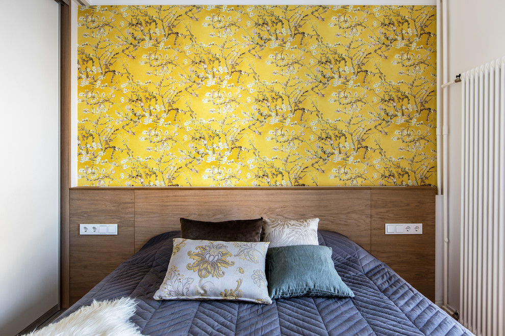 Imagen de dormitorio principal actual con paredes amarillas