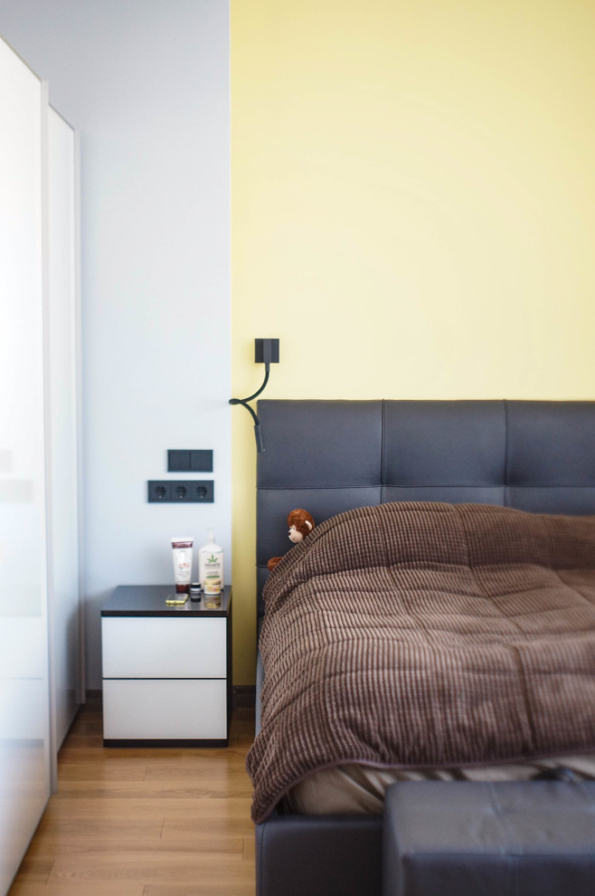 Aménagement d'une petite chambre parentale scandinave avec un mur gris, un sol en bois brun et un sol beige.
