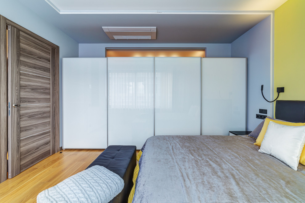 Ispirazione per una piccola camera matrimoniale contemporanea con pareti grigie, pavimento in legno massello medio e pavimento beige