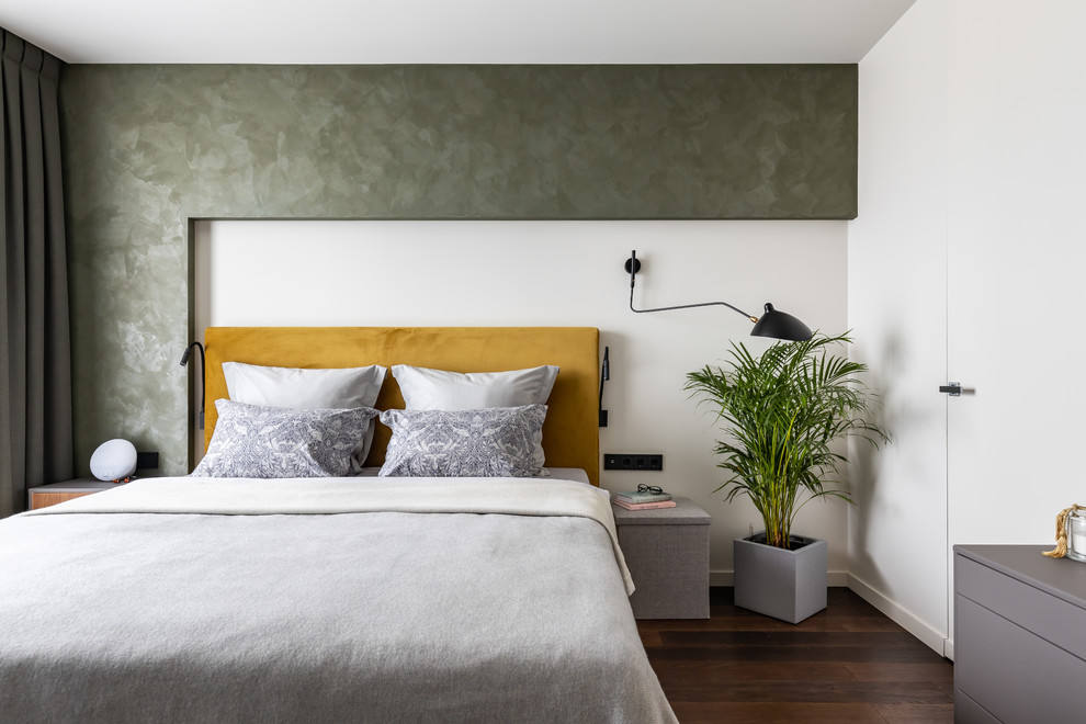 Foto di una camera matrimoniale minimal con pareti verdi, pavimento in legno massello medio e pavimento marrone
