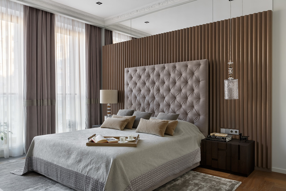 Стильный дизайн: хозяйская спальня: освещение в современном стиле с бежевыми стенами, паркетным полом среднего тона и коричневым полом - последний тренд