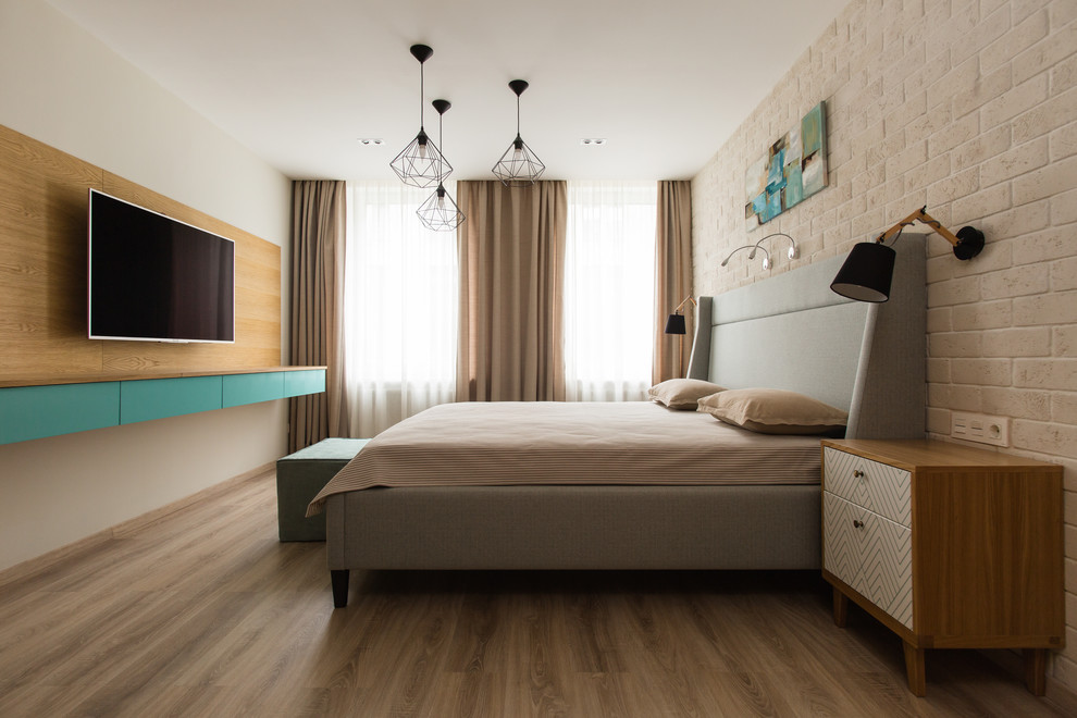 Esempio di una camera matrimoniale minimal con pareti beige, pavimento in legno massello medio, pavimento marrone e TV
