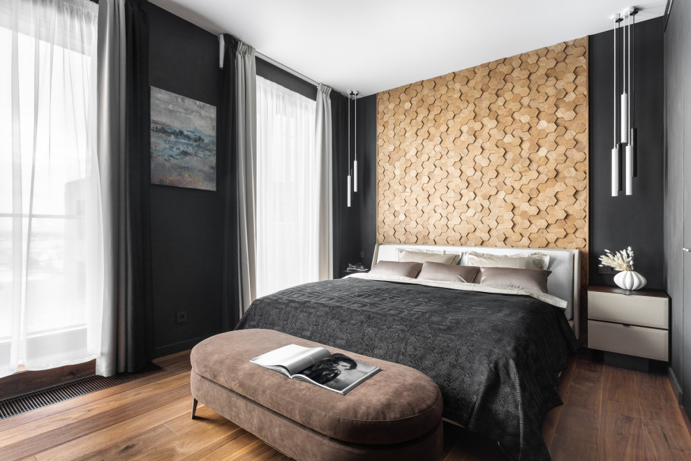 Imagen de dormitorio principal contemporáneo de tamaño medio con paredes negras, suelo de madera en tonos medios y suelo marrón