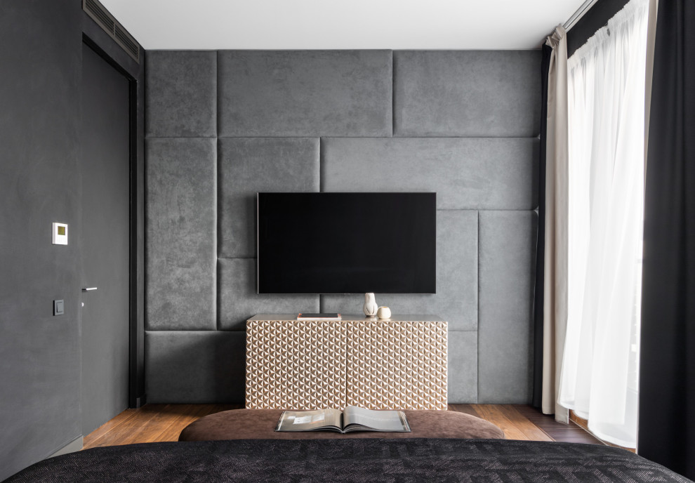 Diseño de dormitorio principal actual de tamaño medio con paredes negras, suelo de madera en tonos medios, suelo marrón y boiserie