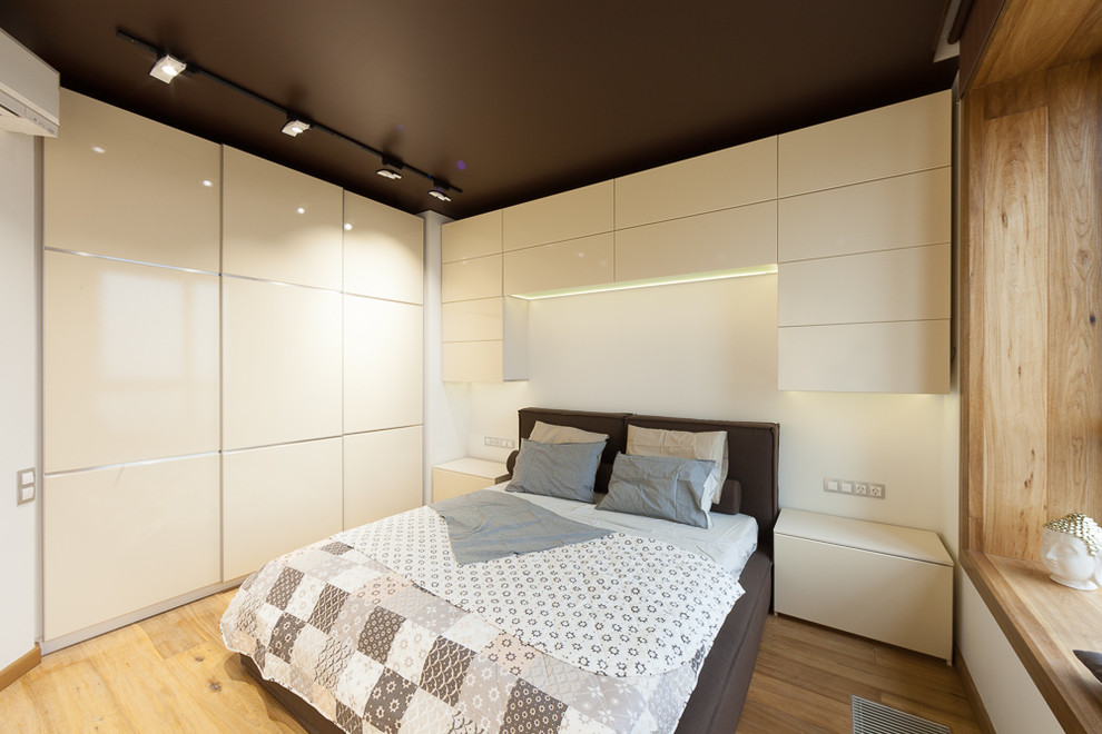 Kleines Modernes Hauptschlafzimmer mit beiger Wandfarbe und hellem Holzboden in Moskau