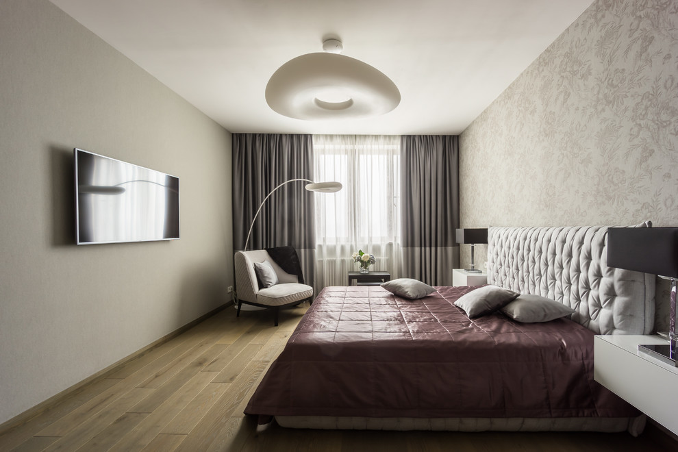 Immagine di una camera matrimoniale minimal di medie dimensioni con pareti grigie, pavimento in legno massello medio e pavimento marrone