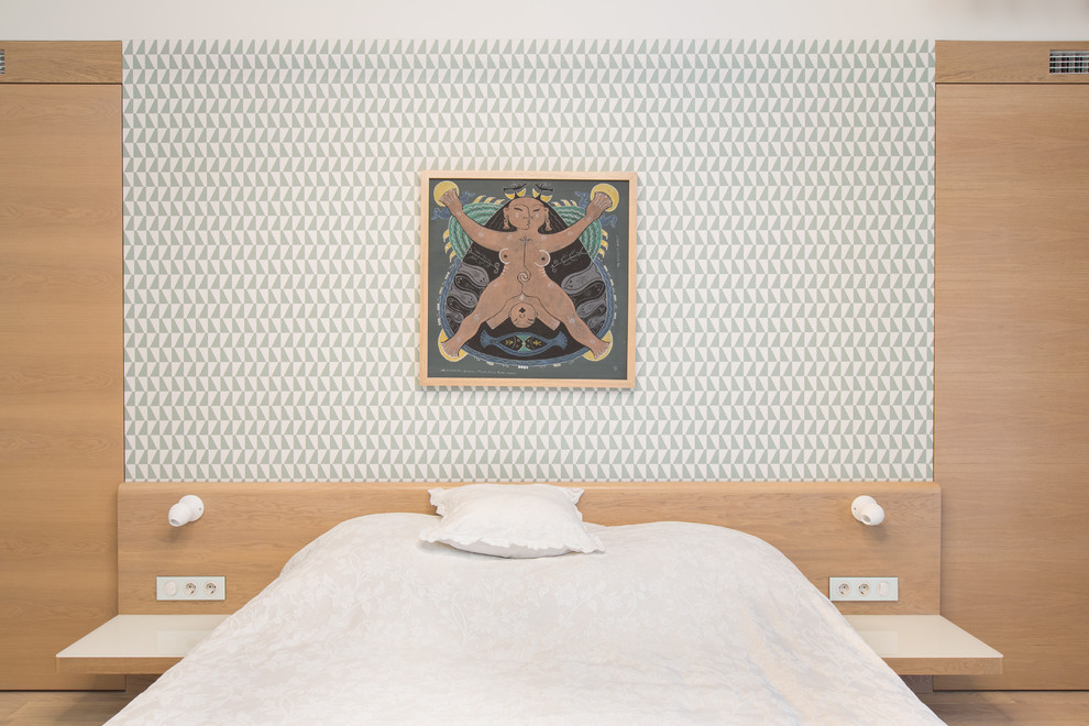 На фото: большая хозяйская спальня в скандинавском стиле с белыми стенами и светлым паркетным полом