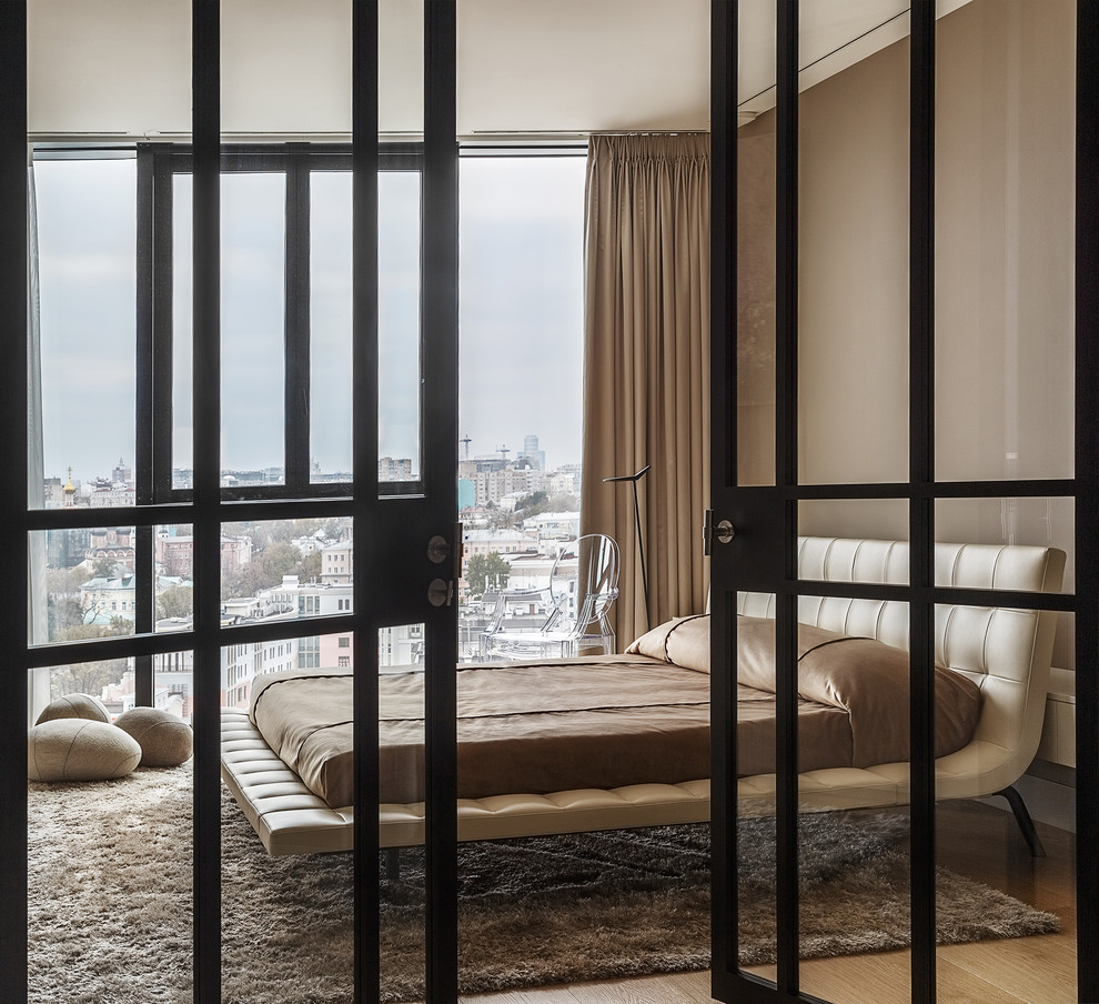 Modernes Hauptschlafzimmer mit beiger Wandfarbe und braunem Holzboden in Moskau