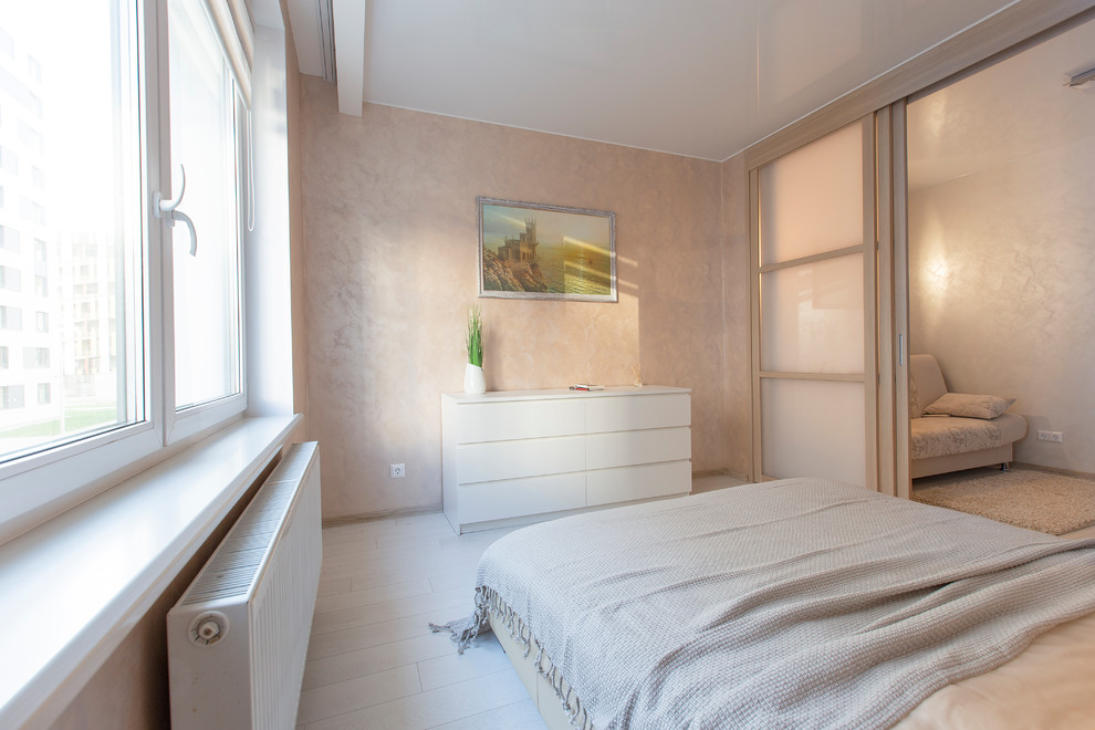 Diseño de dormitorio principal contemporáneo de tamaño medio con paredes rosas, suelo laminado y suelo blanco