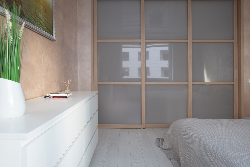 Идея дизайна: хозяйская спальня среднего размера в современном стиле с розовыми стенами, полом из ламината и белым полом