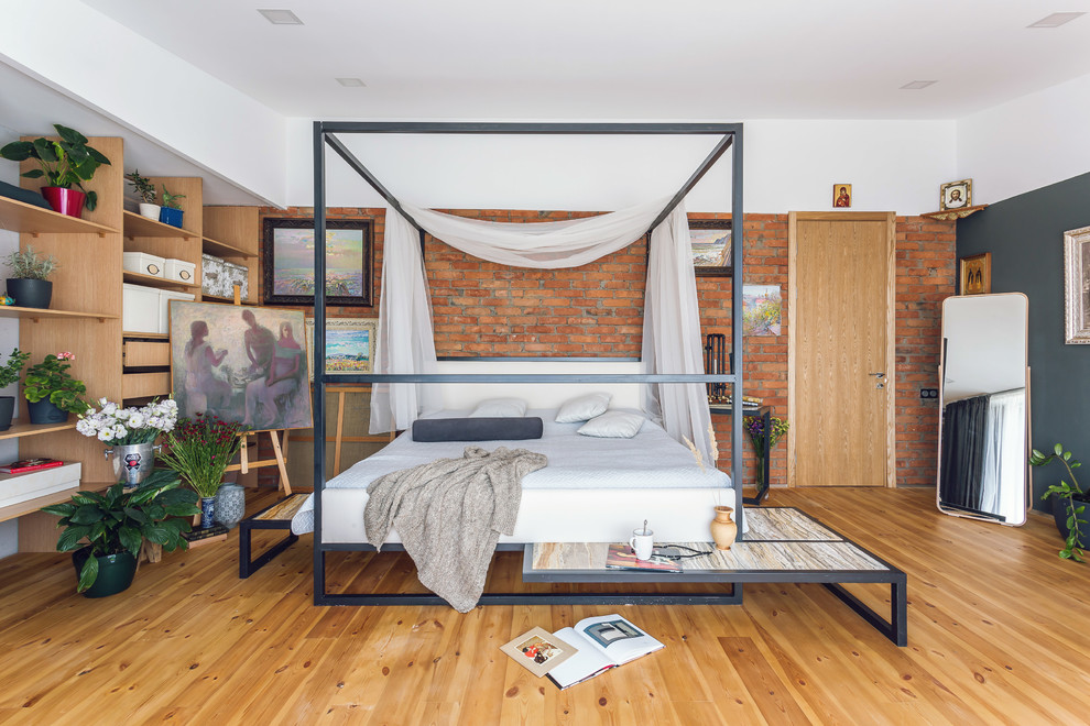 На фото: хозяйская спальня в стиле лофт с серыми стенами, паркетным полом среднего тона и коричневым полом