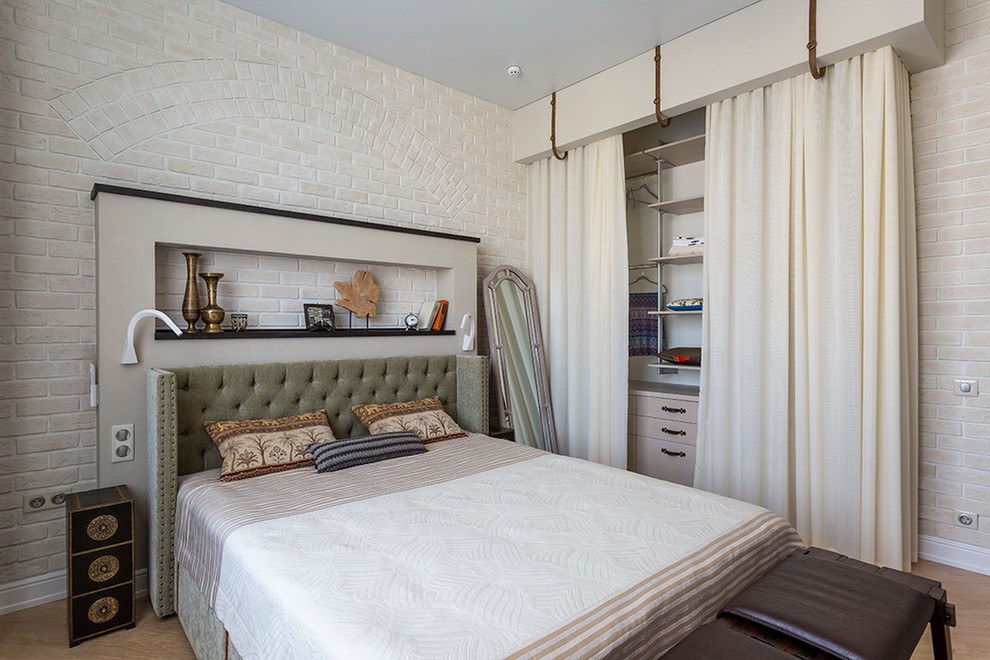 Ispirazione per una camera matrimoniale design con pareti beige e pavimento in legno massello medio
