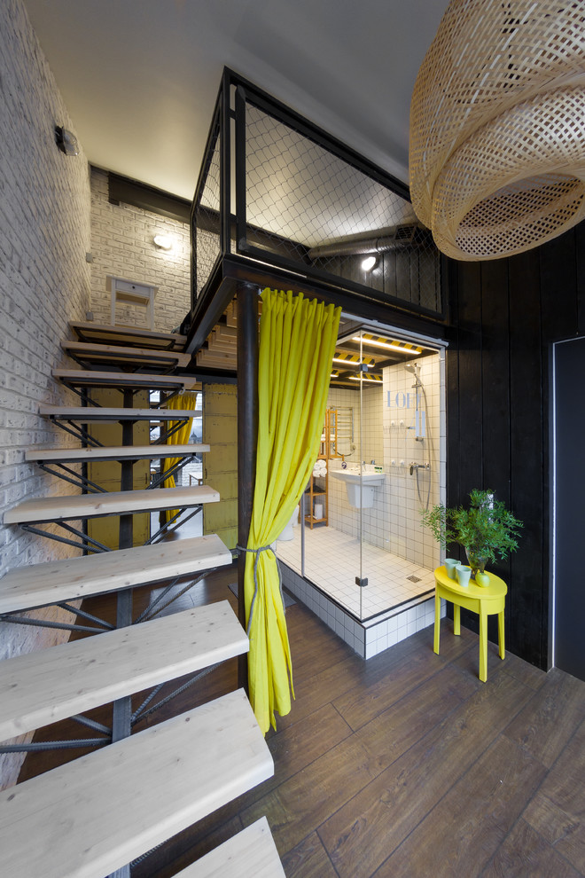 Diseño de dormitorio tipo loft urbano grande con suelo de madera en tonos medios y paredes multicolor