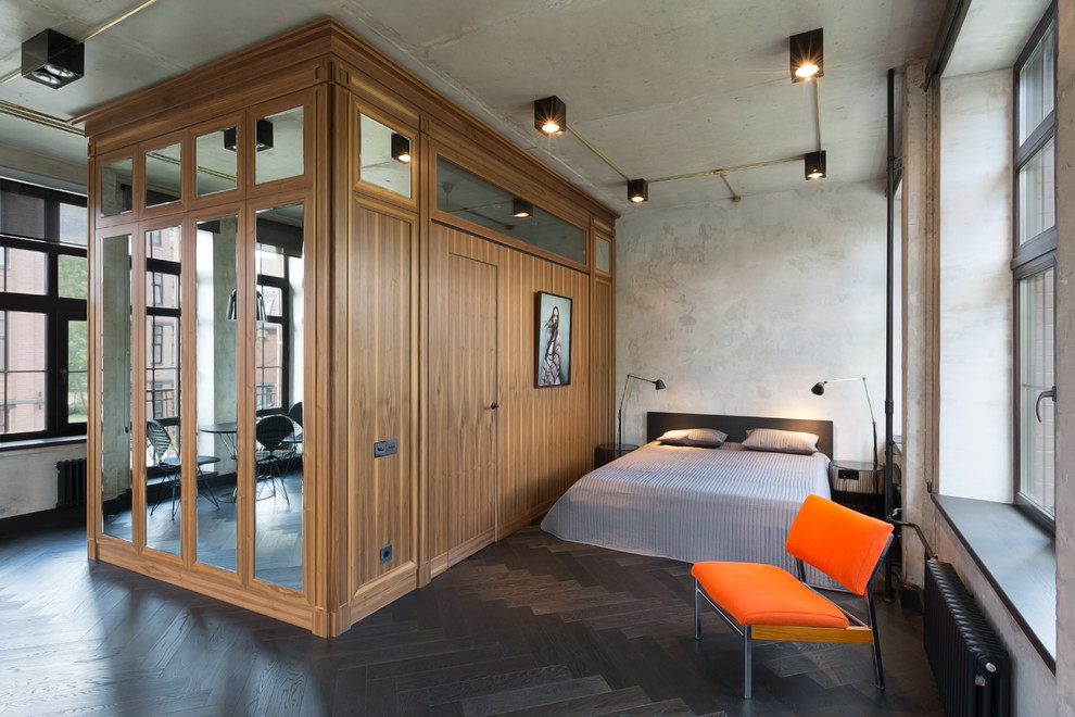 Пример оригинального дизайна: хозяйская спальня в стиле лофт с серыми стенами и темным паркетным полом