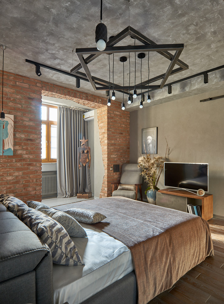 Foto de dormitorio principal industrial con suelo de madera en tonos medios, suelo marrón y paredes grises