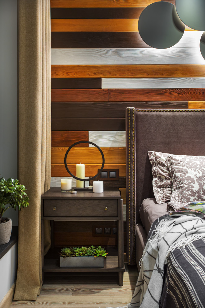 Modelo de dormitorio principal pequeño con paredes multicolor, suelo de madera en tonos medios y suelo beige