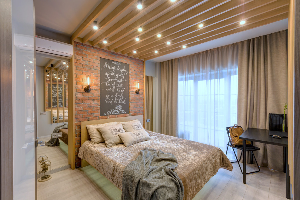 Modelo de dormitorio principal industrial pequeño con paredes grises, suelo laminado y suelo gris
