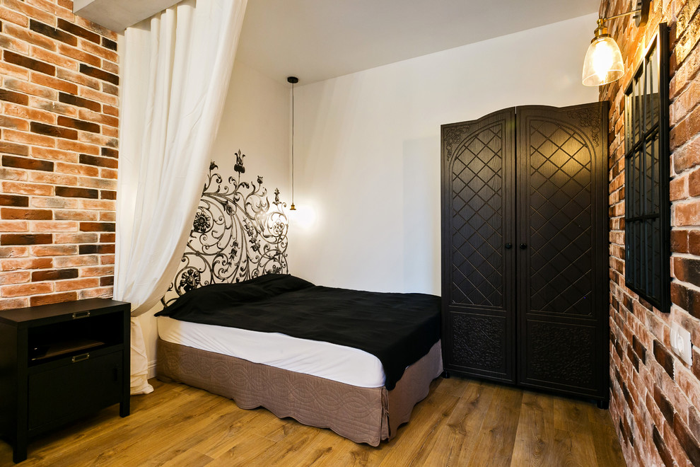 На фото: спальня в стиле лофт с белыми стенами и коричневым полом с