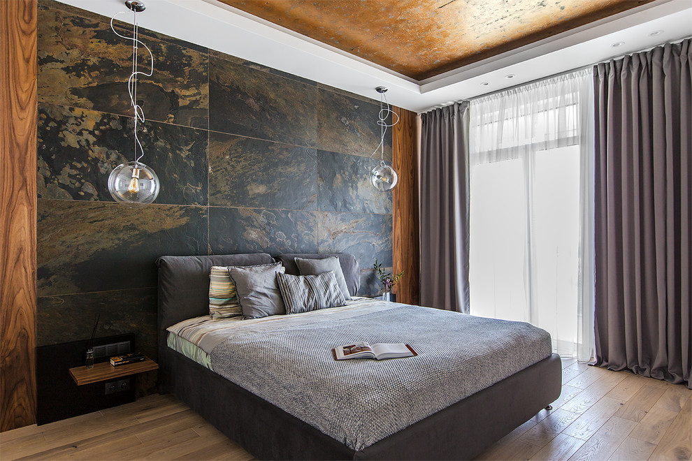 Diseño de dormitorio contemporáneo con paredes blancas, suelo de madera clara y suelo marrón