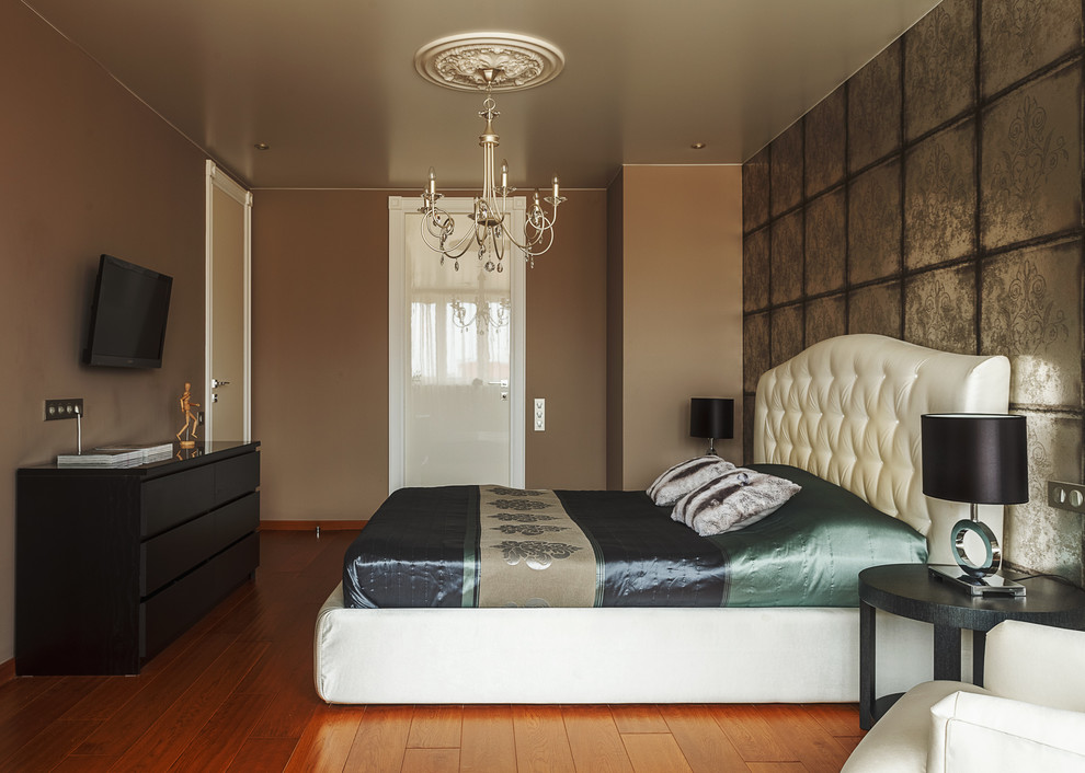 Imagen de dormitorio principal bohemio de tamaño medio sin chimenea con paredes beige, suelo de madera en tonos medios y suelo naranja