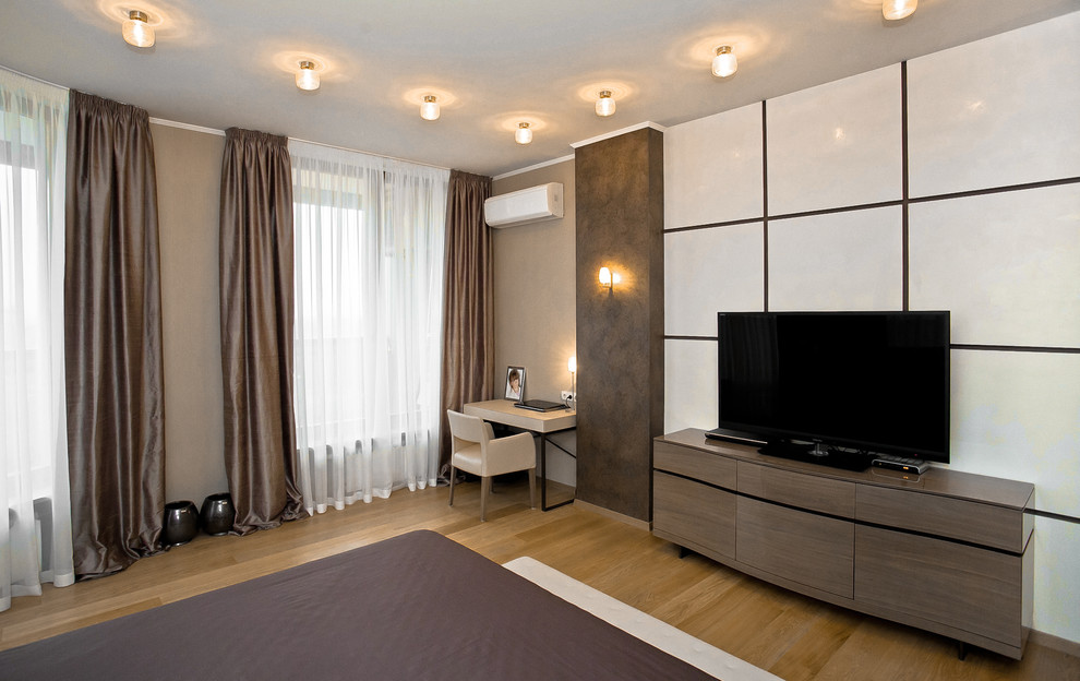 Imagen de habitación de invitados actual de tamaño medio sin chimenea con paredes beige, suelo de madera en tonos medios y suelo amarillo