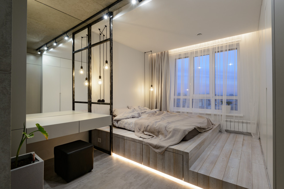 На фото: спальня в современном стиле с белыми стенами, светлым паркетным полом и бежевым полом без камина