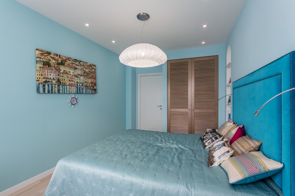 Idee per una camera degli ospiti mediterranea con pareti blu e parquet chiaro