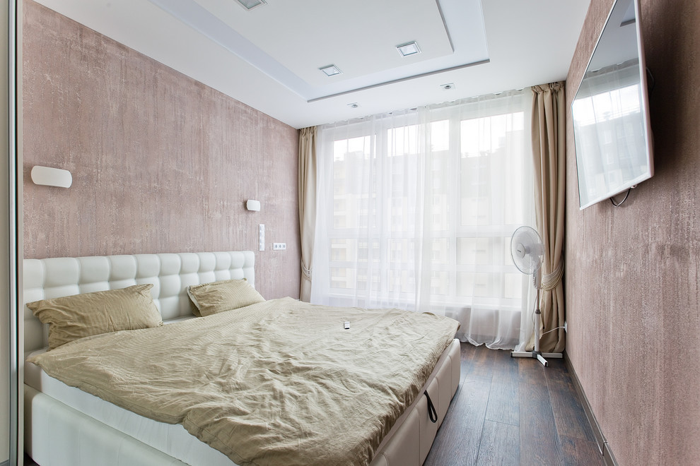 Foto de dormitorio principal contemporáneo pequeño con paredes rosas, suelo laminado y suelo marrón