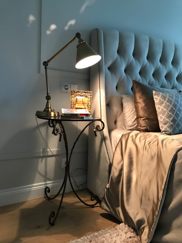 Imagen de dormitorio urbano con paredes grises, suelo de madera en tonos medios y suelo beige