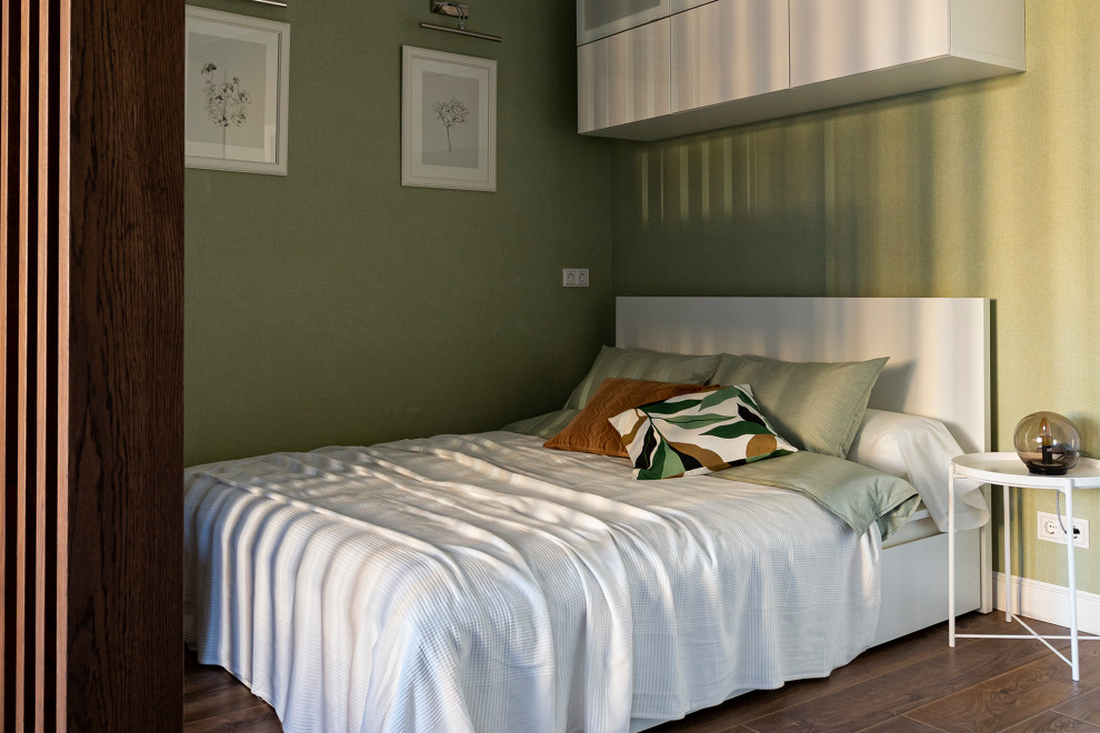 Foto di una piccola camera da letto minimal con pareti verdi, pavimento in laminato e pavimento marrone
