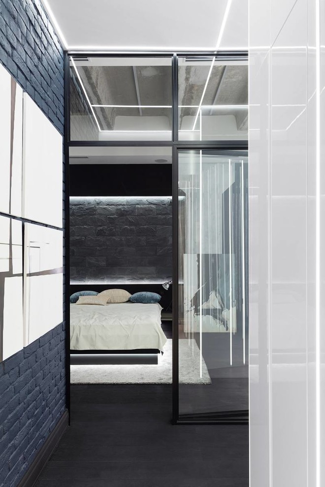 На фото: хозяйская спальня среднего размера в современном стиле с синими стенами, темным паркетным полом и коричневым полом без камина с