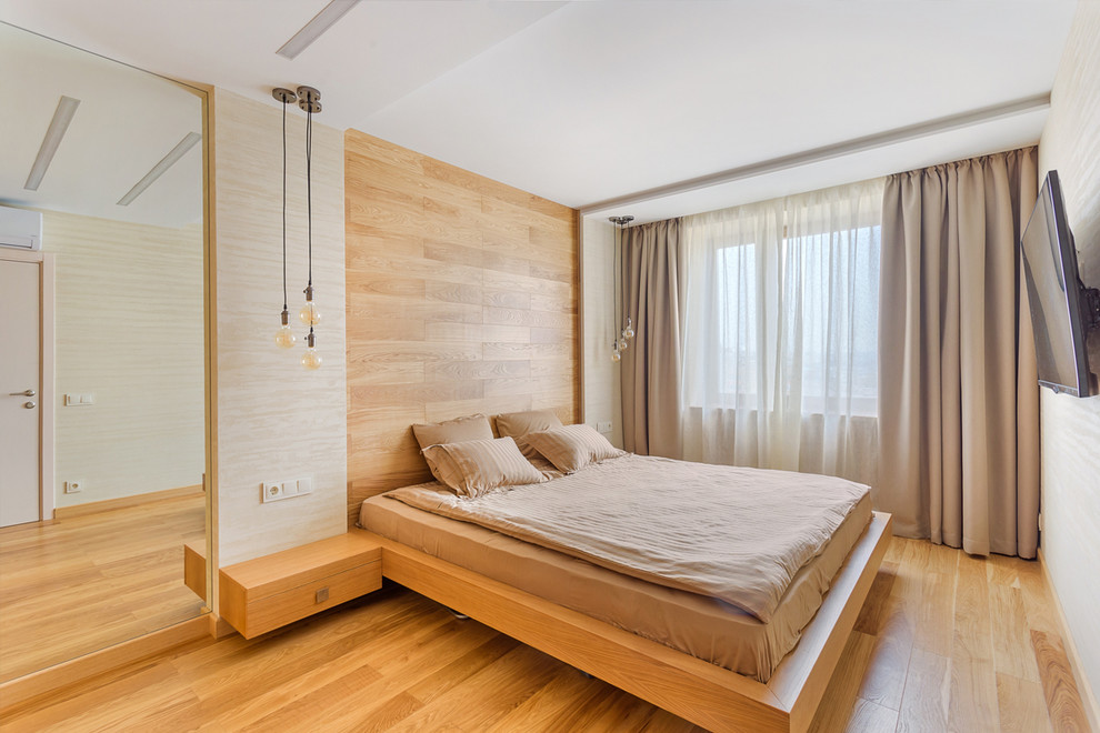 Ispirazione per una piccola camera matrimoniale design con pareti grigie, pavimento in legno massello medio e pavimento marrone