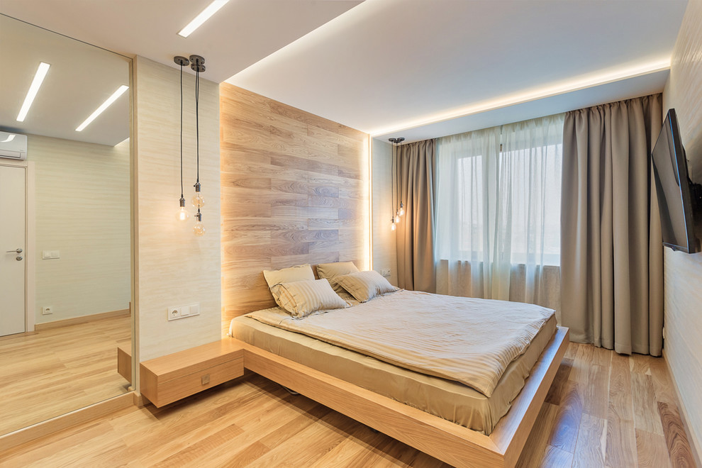 Cette image montre une petite chambre parentale design avec un mur gris, un sol en bois brun et un sol marron.