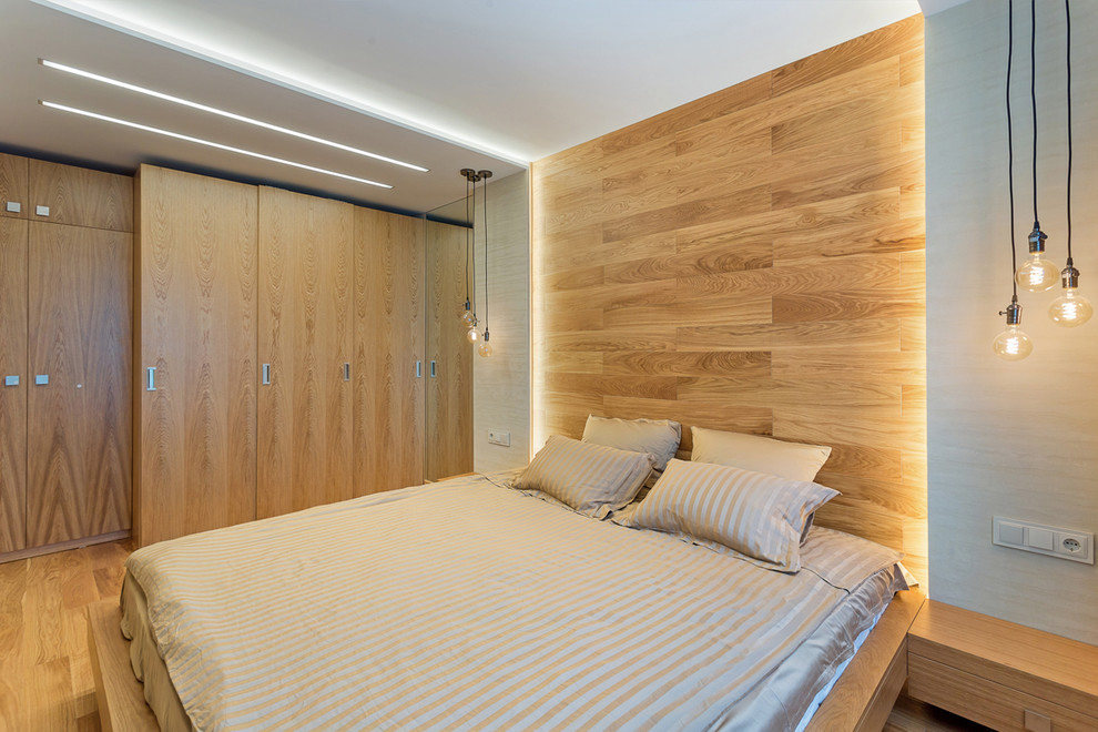 Esempio di una piccola camera matrimoniale minimal con pareti grigie, pavimento in legno massello medio e pavimento marrone