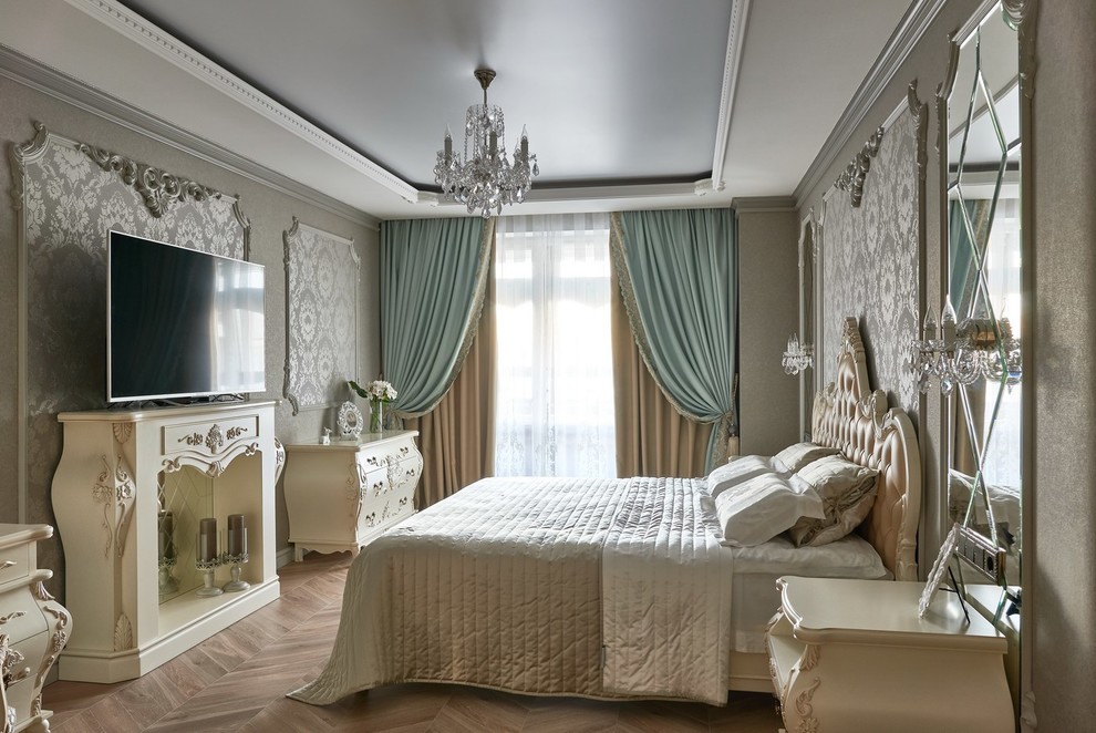 Foto di una camera matrimoniale vittoriana con pareti grigie, pavimento in legno massello medio, camino classico e TV