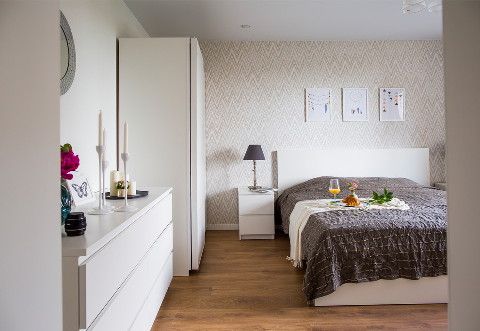 На фото: спальня в скандинавском стиле с серыми стенами, паркетным полом среднего тона и коричневым полом с