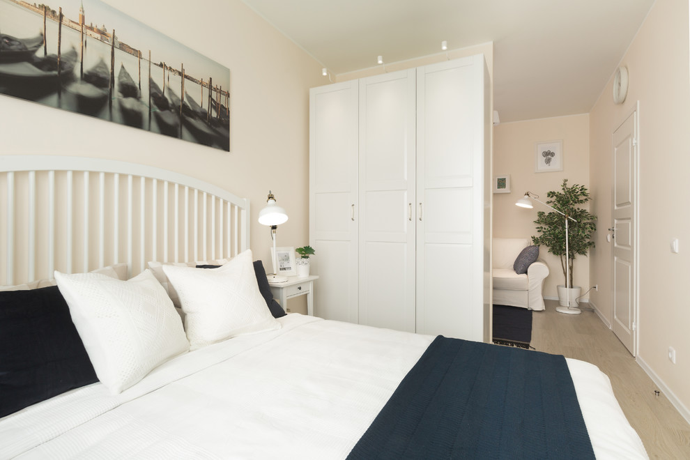 Imagen de dormitorio principal nórdico de tamaño medio con paredes beige, suelo laminado y suelo beige